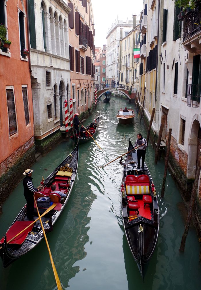 Charming view of gondolas navigating a Venice canal with historic architecture lining the waterway.